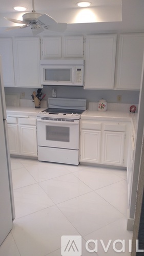 A kitchen with white cabinets and appliances.