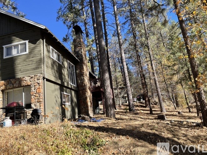 A house with a stone wall and a red object outside.