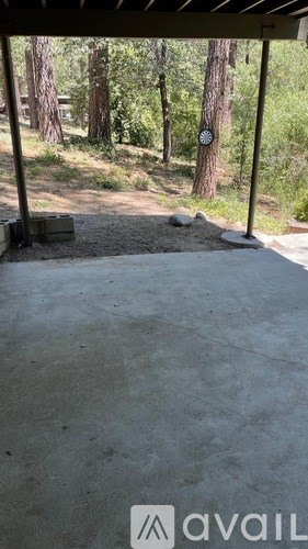 A concrete patio with a dart board in the background.