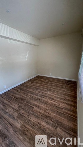 A room with wooden flooring and white walls.