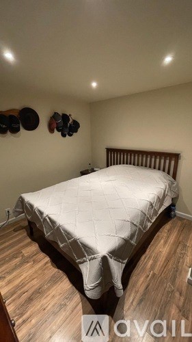 A bedroom with a bed and a wooden floor.