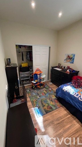 A room with a bed, a dresser, and a bookshelf.