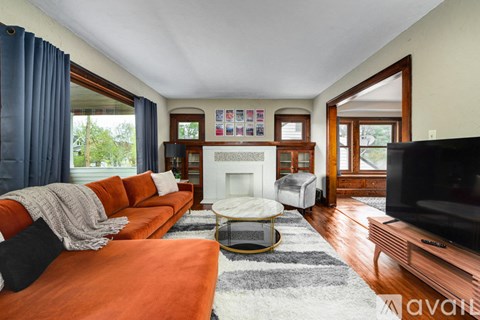 A living room with orange couches and a fireplace.