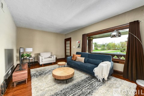 A living room with a blue couch and a wooden coffee table.