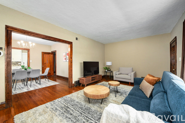 A living room with a blue couch and a wooden coffee table.