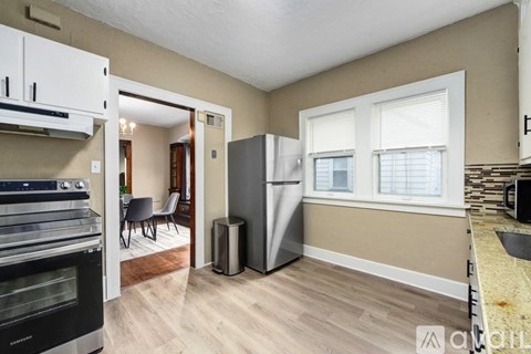 A kitchen with a stove top oven and a refrigerator.