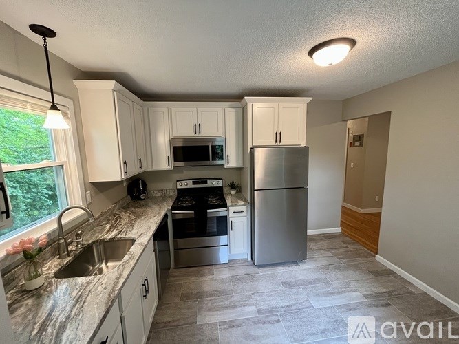 A kitchen with a sink, stove, and refrigerator.