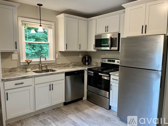 A kitchen with white cabinets and stainless steel appliances.