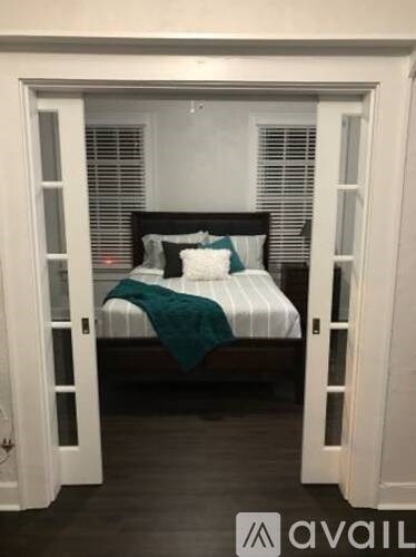 A bedroom with a bed and a window.