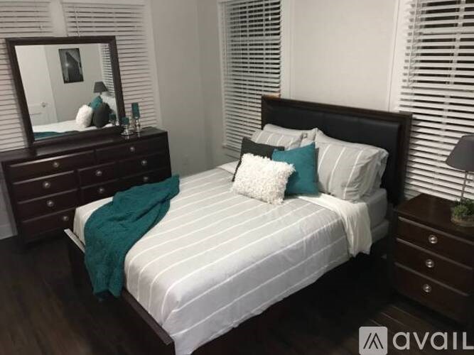 A bedroom with a bed, nightstand, and a mirror.