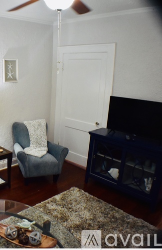 A living room with a grey chair and a black fireplace.