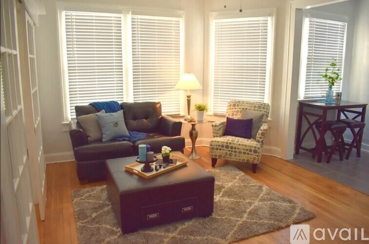 A living room with a brown couch, a chair, and a coffee table.