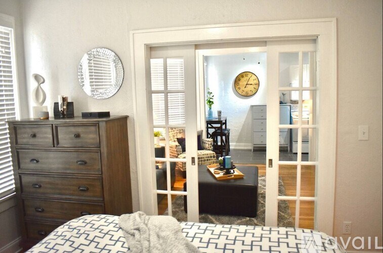 A bedroom with a bed, dresser, and mirror.