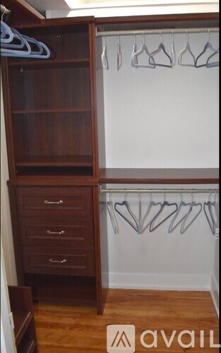 A wooden wardrobe with a white wall behind it.