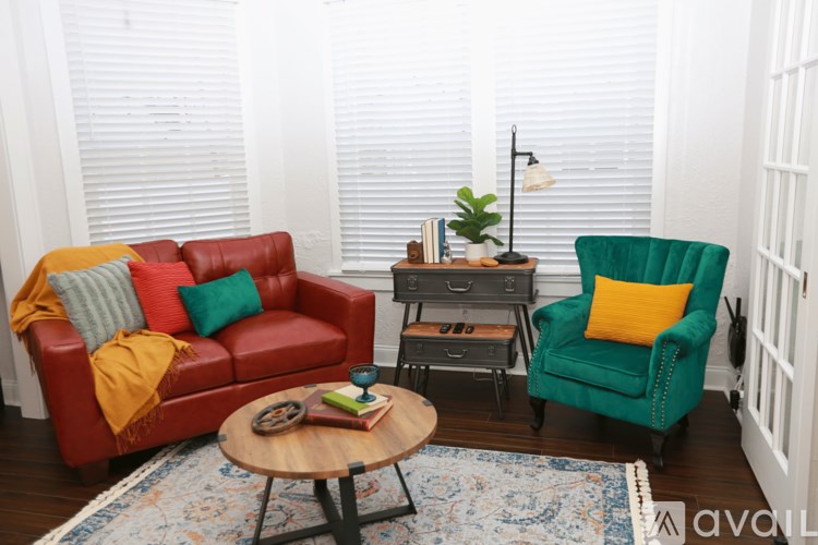 A living room with a red couch, green armchair, and a wooden coffee table.