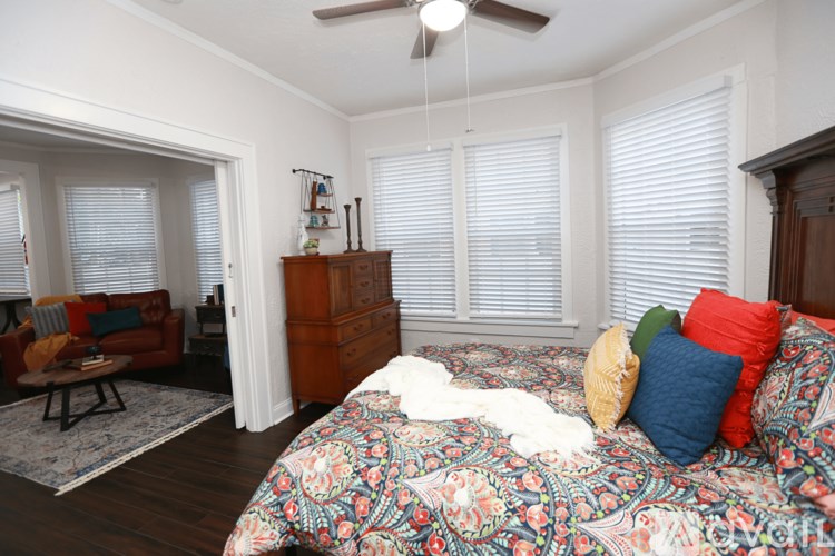 A bedroom with a bed, a dresser, and a couch.
