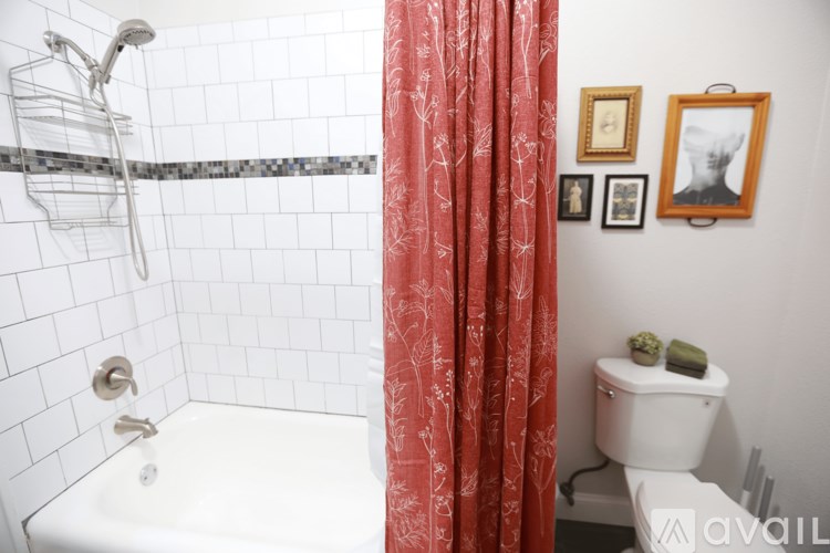 A bathroom with a white tub and a red shower curtain.