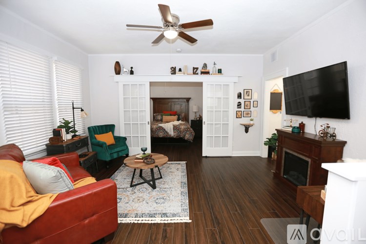 A living room with a red couch, a coffee table, and a fireplace.