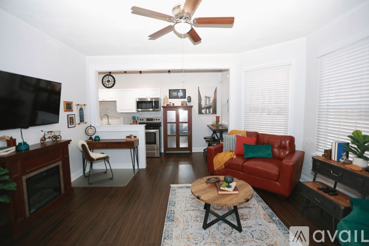 A living room with a red couch and a wooden coffee table.