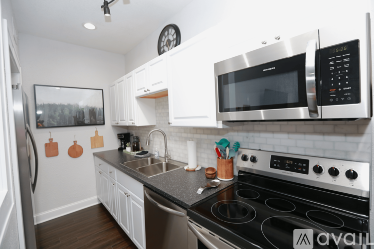 A kitchen with a stove, microwave, and oven.