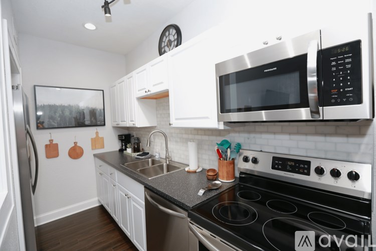 A kitchen with a stove, microwave, and oven.