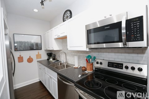 A kitchen with a stove, microwave, and oven.