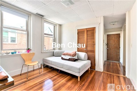 A living room with a white couch and a wooden floor.