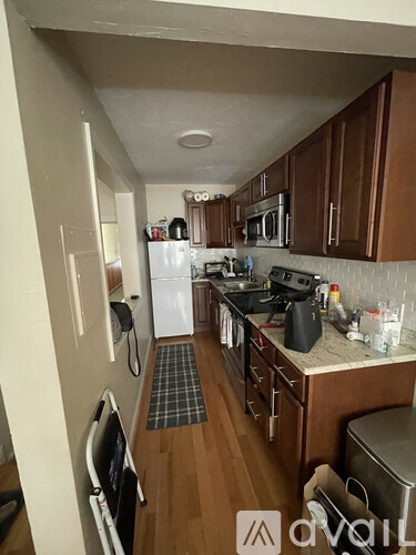 A kitchen with wooden cabinets and a white fridge.
