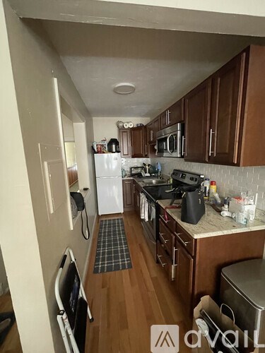 A kitchen with wooden cabinets and a white fridge.