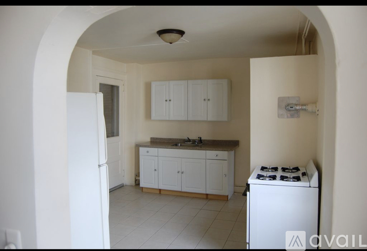 A kitchen with white cabinets and a white gas stove.
