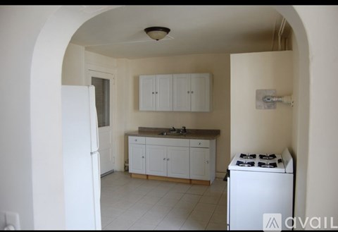 A kitchen with white cabinets and a white gas stove.