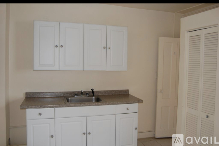 A kitchen with white cabinets and a granite countertop.