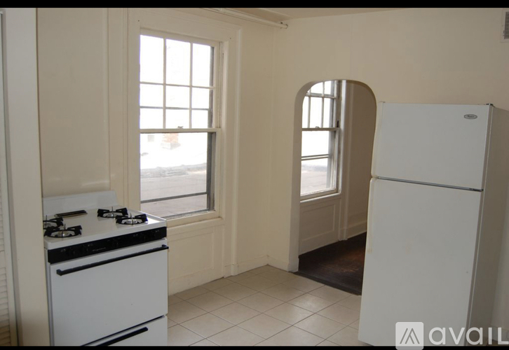 A kitchen with a white stove and a white fridge.