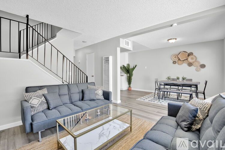 A living room with a grey sofa and a glass coffee table.
