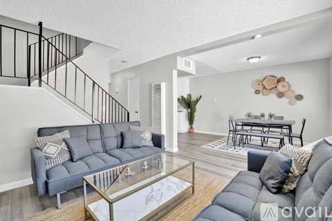A living room with a grey sofa and a glass coffee table.