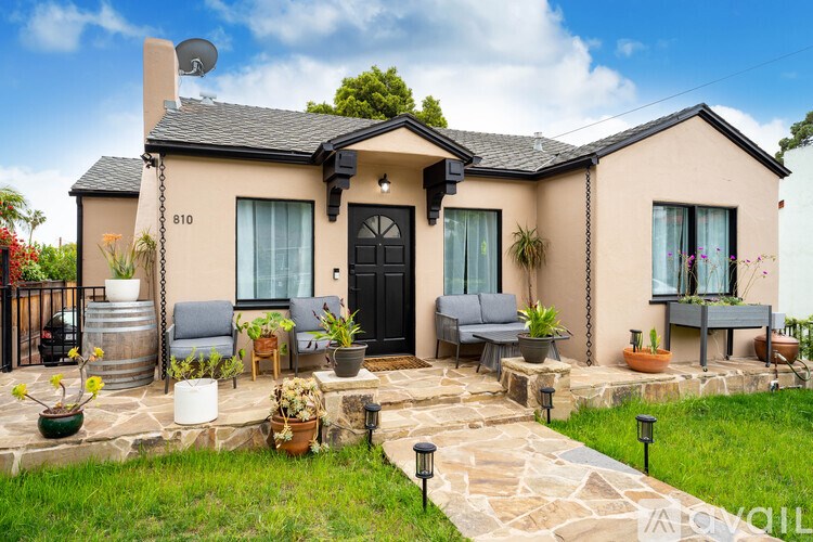 A house numbered 810 with a black door and a stone pathway leading to it.