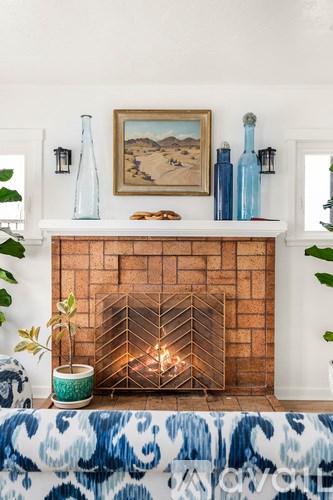 A fireplace with a painting on the wall above it.