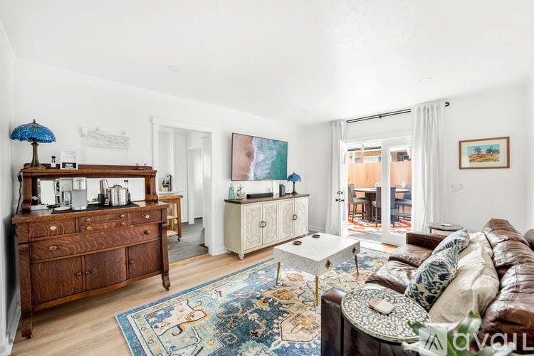 A living room with a brown leather couch and a wooden dresser.