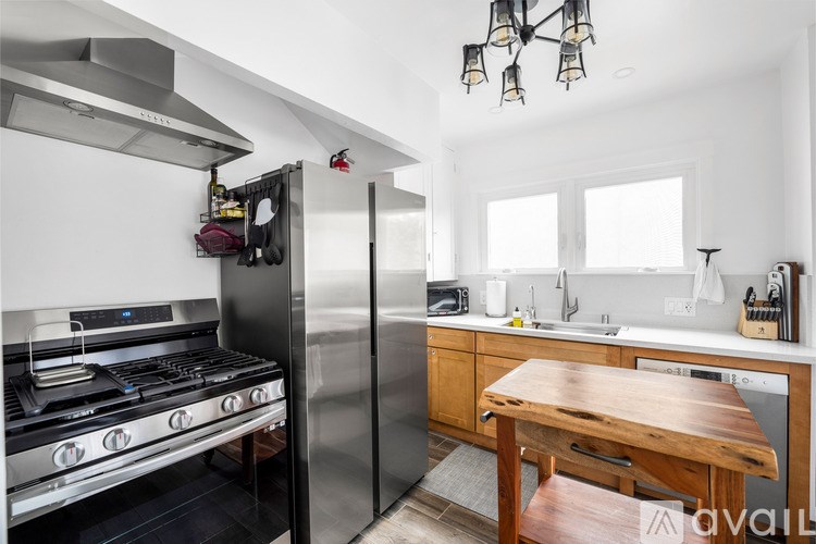 A modern kitchen with a stainless steel refrigerator and a wooden table.