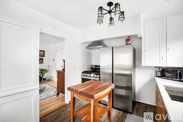 A kitchen with a wooden table and stainless steel appliances.