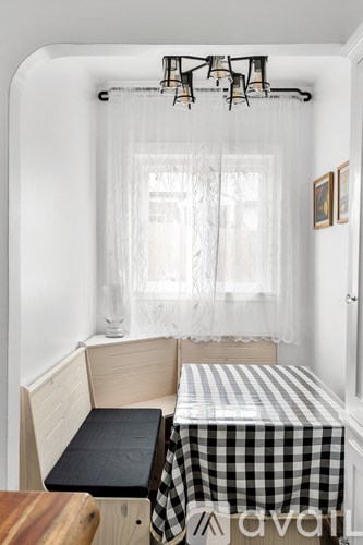 A small room with a checkered tablecloth on the table.