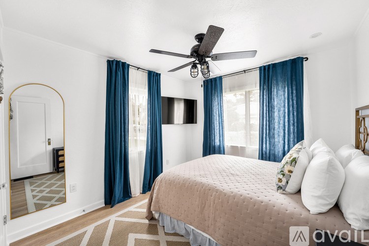 A bedroom with a bed, a ceiling fan, and a rug.