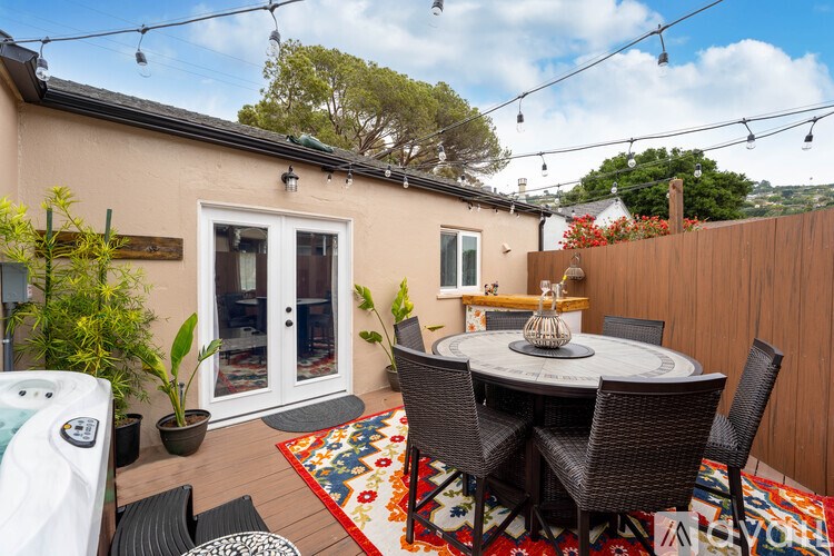 A patio with a table and chairs is set up outside a house.