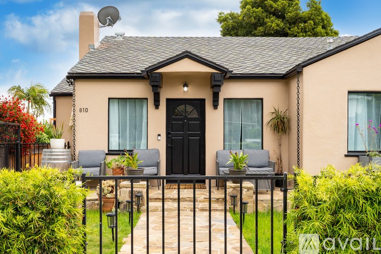 A house with a black front door and a satellite dish on the roof.