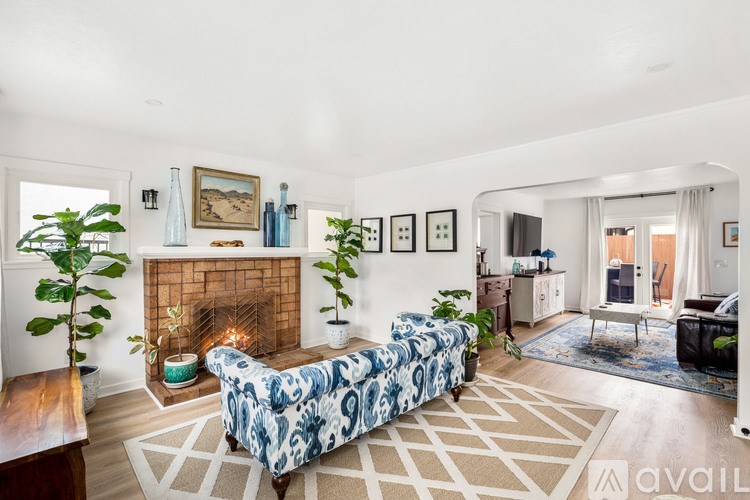 A living room with a fireplace and a blue and white patterned couch.