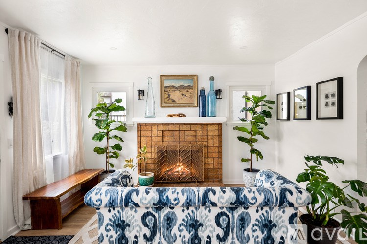 A cozy living room with a fireplace and a blue and white patterned sofa.