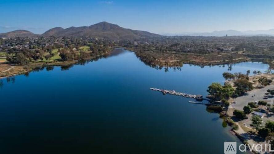 A large body of water with a mountain in the background and a dock with boats.
