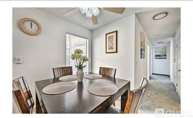 A dining room with a table set for four.