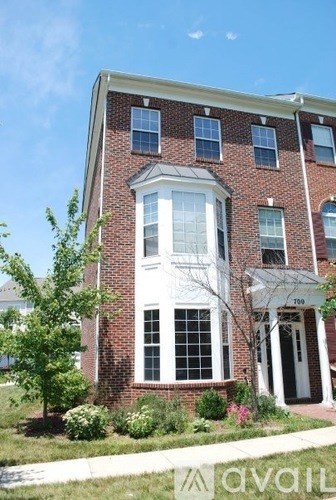 A red brick building with a white door and windows.