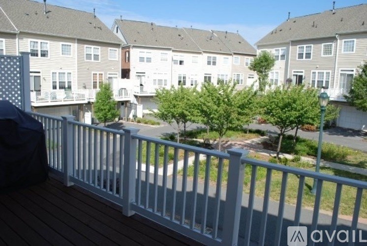 A white fence in front of apartment buildings.